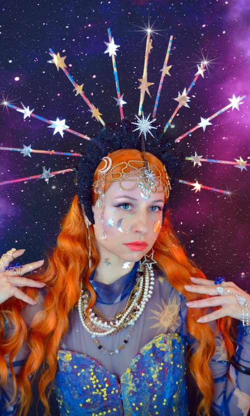 A redhead woman with astrology costume based aesthetic colors and items.