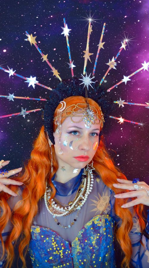 A redhead woman with astrology costume based aesthetic colors and items.